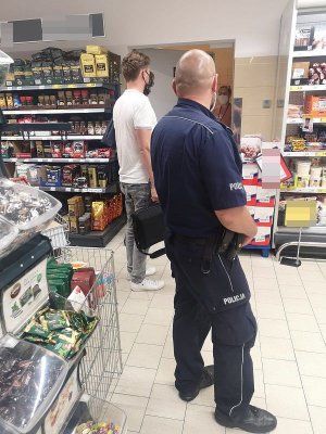 Policjant wspólnie z przedstawicielem nakielskiego sanepidu podczas kontroli sklepu